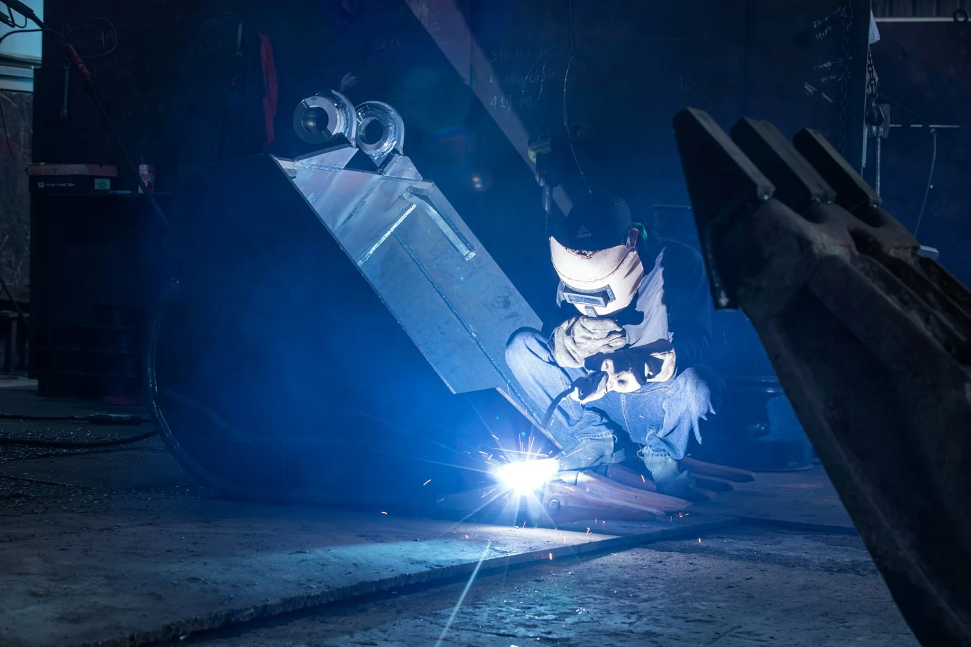 Welder carrying out metal fabrication with protective equipment